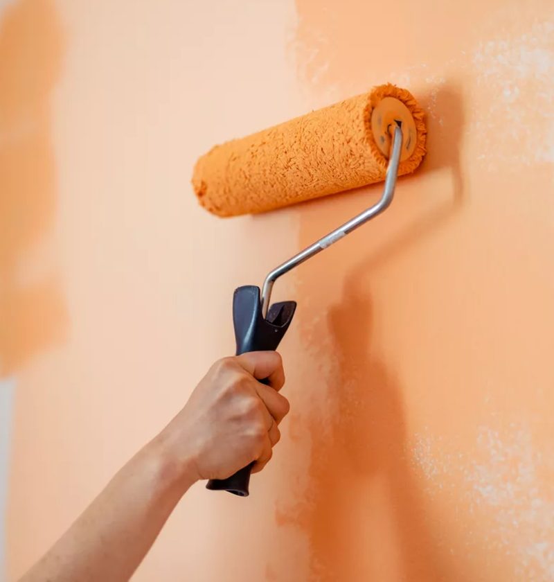 Paint roller applying a finish coat to an interior wall